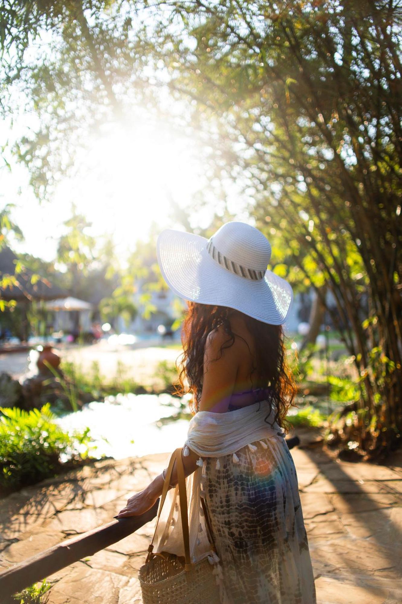 Diamonds Leisure Beach & Golf Resort Diani Beach Exterior foto A woman wearing a sun hat