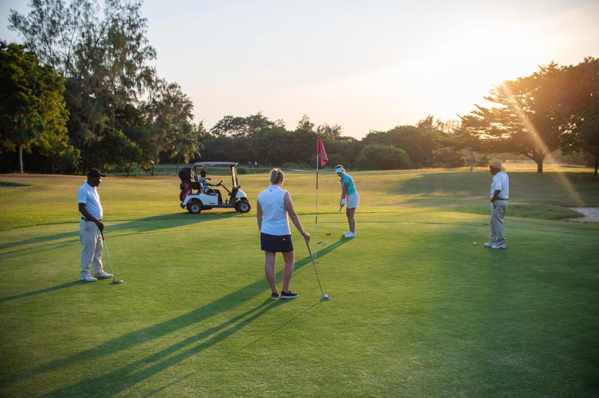 Diamonds Leisure Beach & Golf Resort Diani Beach Exterior foto Golfers putting on the 18th green at the Royal Pines Resort